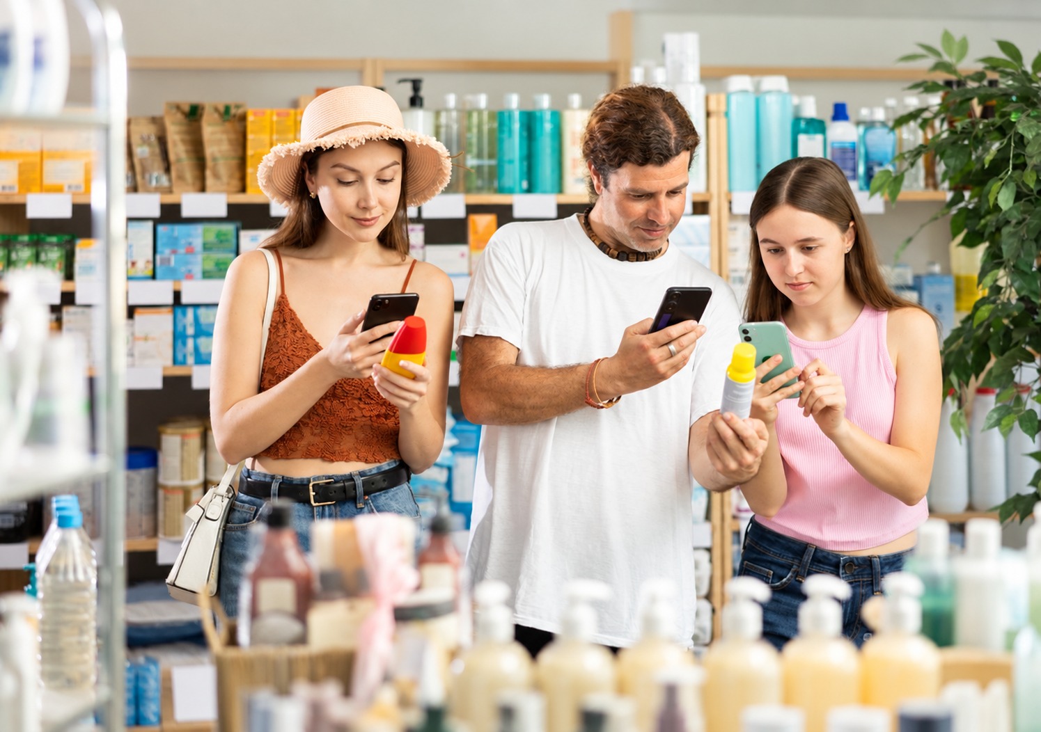 Persone che consultano sullo smartphone informazioni sugli ingredienti di prodotti cosmetici